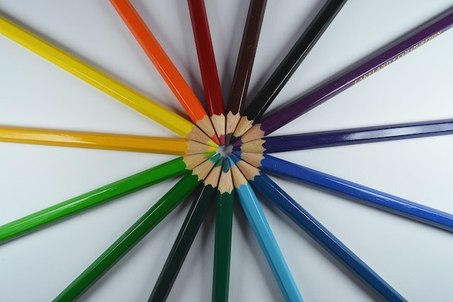 gekleurde potloden liggen in een cirkel met de punt naar elkaar toe in het midden