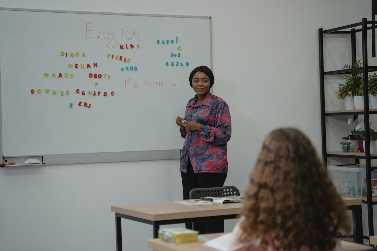 een mevrouw geeft Engelse taalles in een klaslokaal